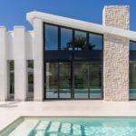 Le vetrate panoramiche sono le protagoniste di questa villa con piscina dallo stile moderno