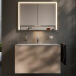 Un ambiente bagno impreziosito da uno specchio contenitore con cornice luminosa a LED