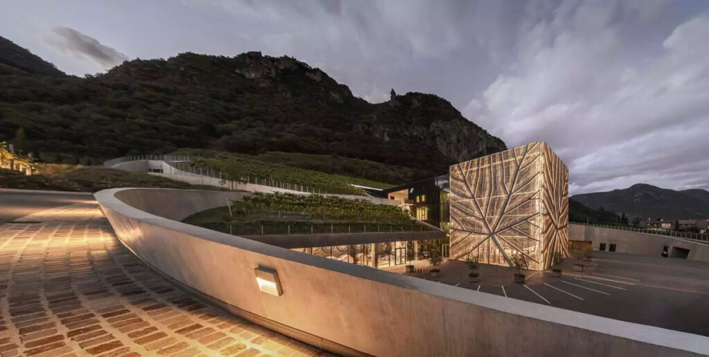 Una lamiera di alluminio traforato color bronzo avvolge la facciata dell’edificio della nuova Cantina di Bolzano. 